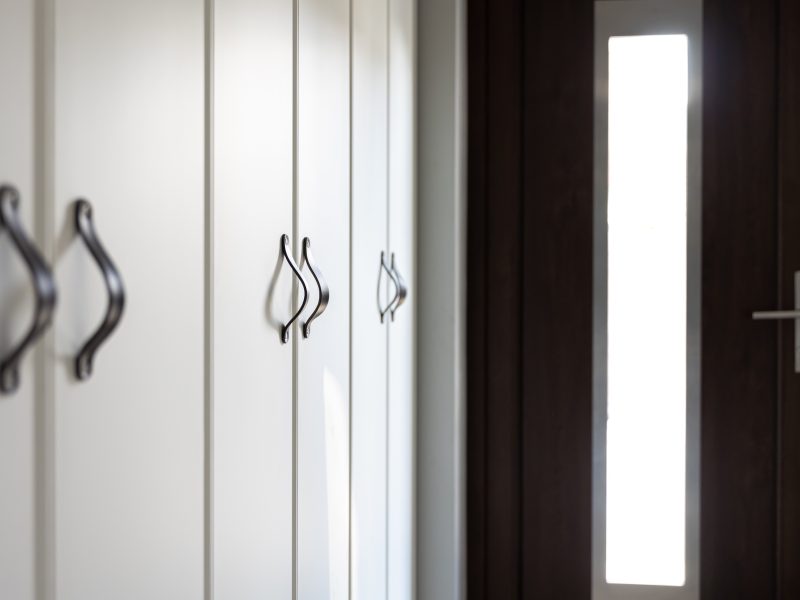 Interior of a modern residential home: detail of black kitchen drawer door handles.