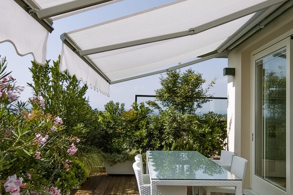 exterior shot of a modern terrace in foreground the dining table whose floor is made of wood